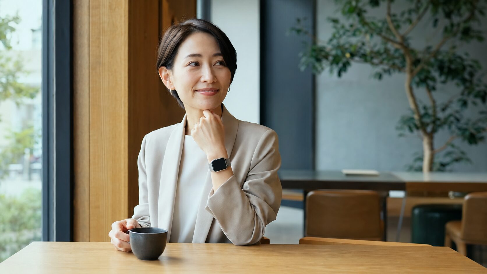 メッシュバンドのスマートウォッチを上品に着けた日本人女性