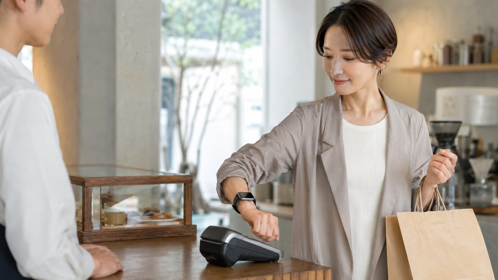 買い物中にスマートウォッチで手元決済する日本人女性